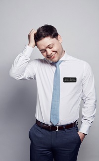 Young businessman wearing engraved leatherette name badge.